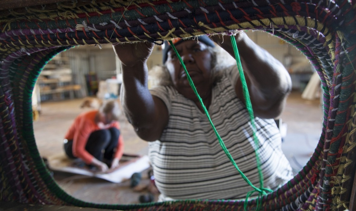 Thelma Judson working on a new sculptural weaving at Parnngurr art shed, with Claire Healy in the background, 2017. Photography by Ruth Leigh. Image courtesy and copyright the artists, Martumili Artists and Fremantle Arts Centre