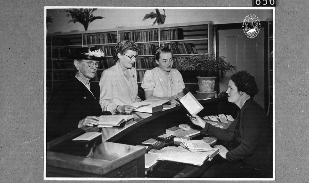 Interior of Fremantle Free Lending Library, 1948, City of Fremantle Local History Collection no. 856. Lily Organ seated at the issue desk in the Fremantle Lending Library , later known as the Evans Davies Civic Library. In front of the desk L-R: Mrs Sloan (borrower), Mrs Francis and Betty Secker