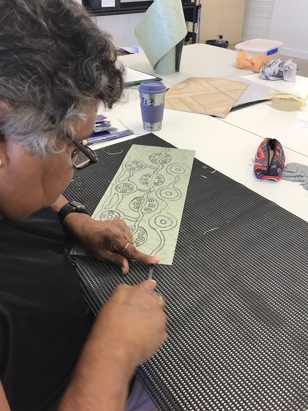 Ku'arlu Mangga artist Colleen Drage carving an image for one of her Revealed 2020 works. Image courtesy of Ku'arlu Mangga