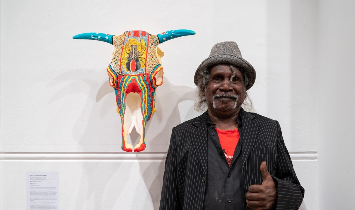 John Prince Siddon at the 45th FAC Print Award Exhibition opening, next to his work Purlkartu (Spider), 2020.